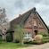 A building in Hamburg’s Altes Land beside a blooming tree